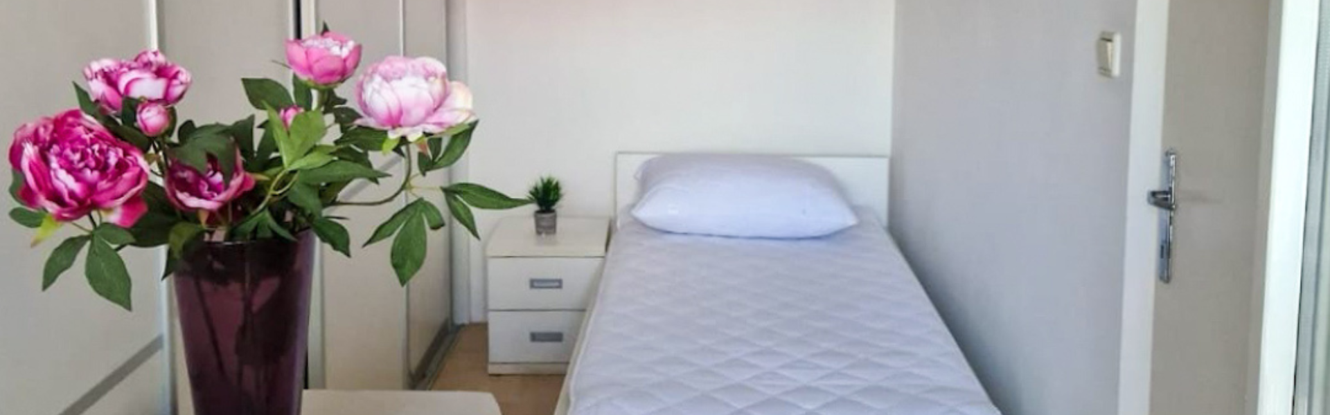 The image shows the bedroom of Room Dugave Three.